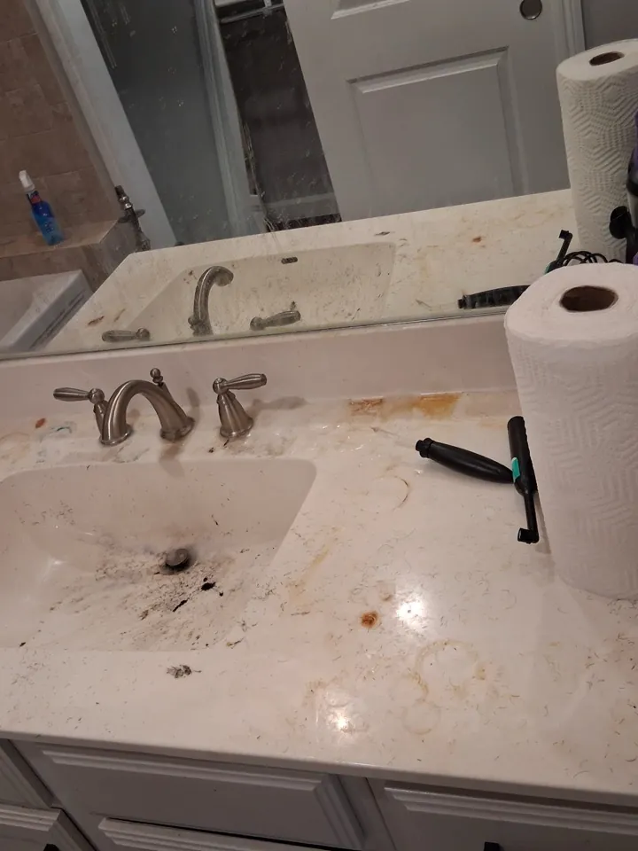 Bathroom vanity cluttered and stained before a deep clean