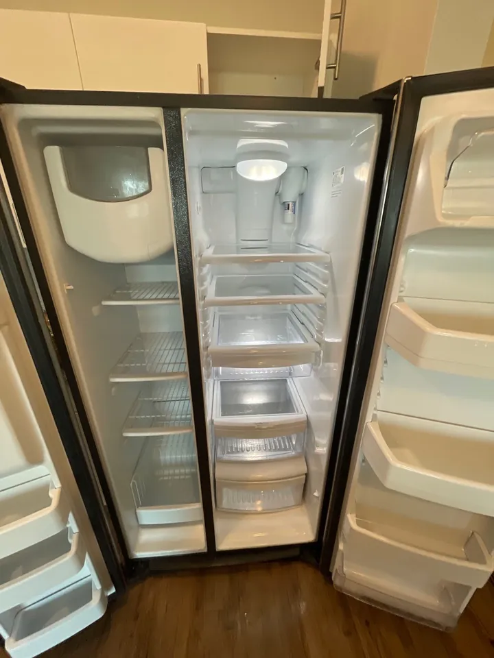 The same refrigerator emptied and wiped down after a move-out clean