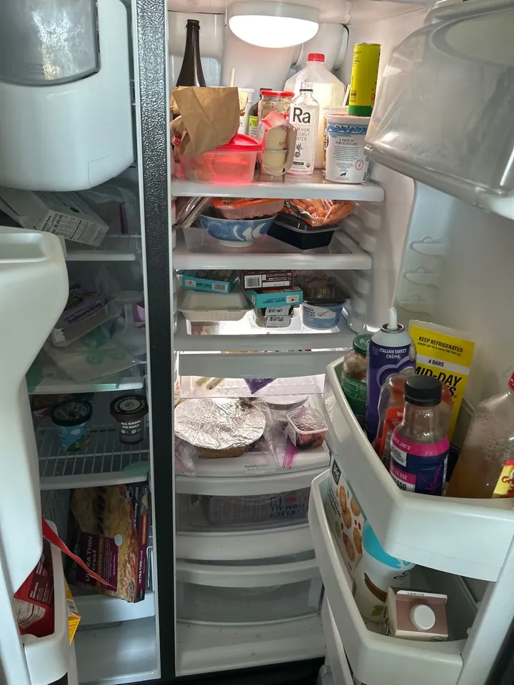 Refrigerator full of leftover food before a move-out clean