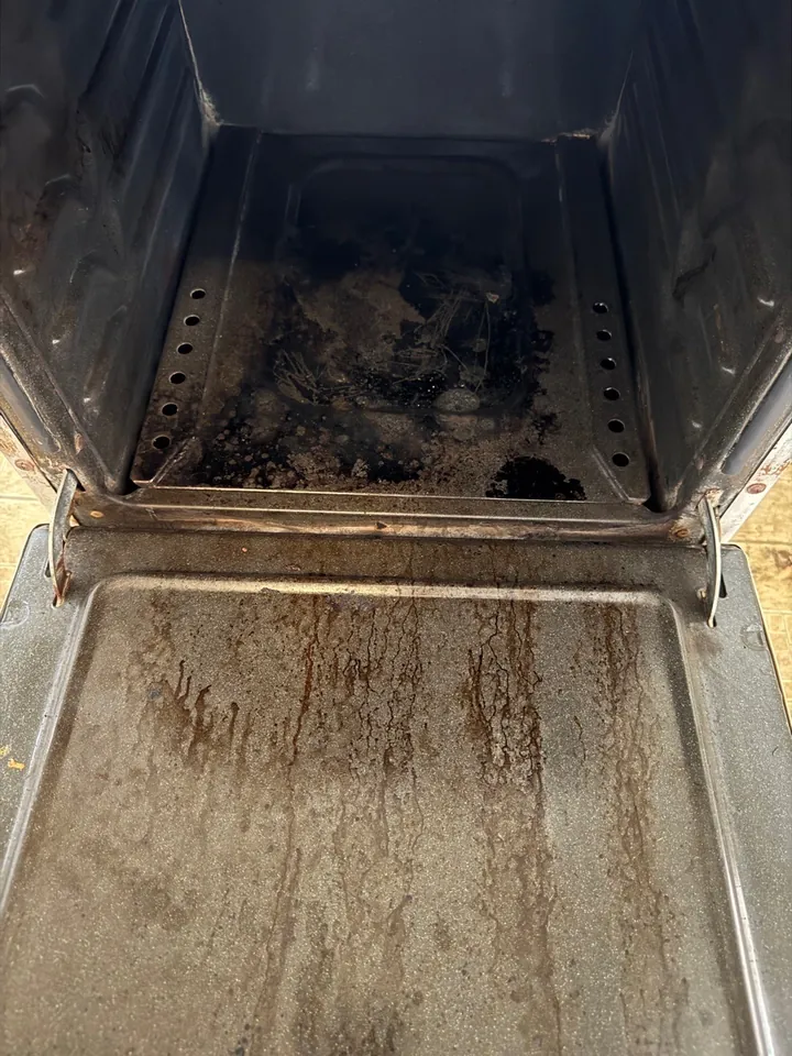 Oven interior with heavy baked-on grease before a move-out clean
