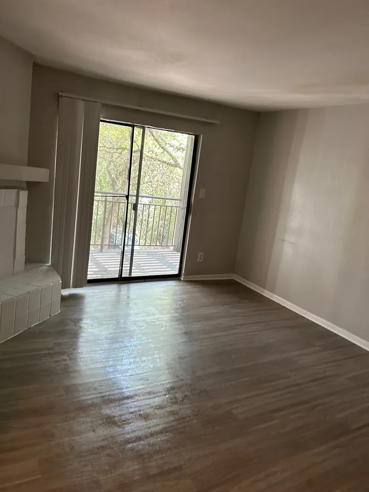 The same living room emptied and floors cleaned after a move-out clean