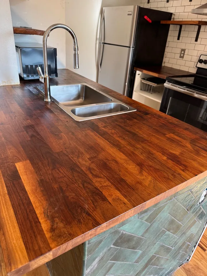 The same butcher-block island cleared and wiped after a post-construction clean