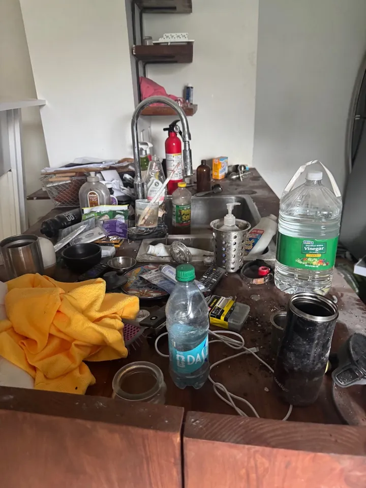 Kitchen island buried under tools and materials before a post-construction clean
